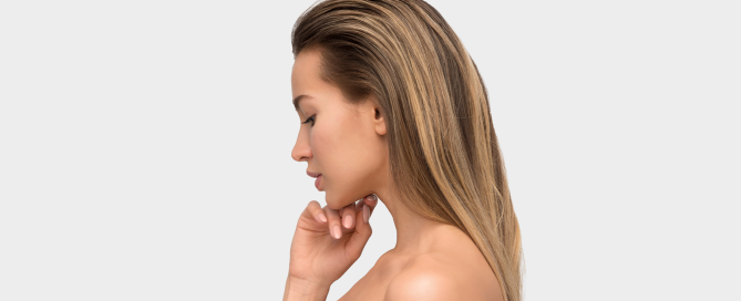 Close-up of a woman applying retinol serum at night as part of her skincare routine.